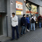 Desempleados ante una oficina del servicio estatal de empleo, en Madrid.-