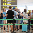 Pasajeros esperan para pasar los controles de seguridad en el aeropuerto de El Prat.-JOAN CORTADELLAS