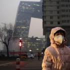 Una niña con una máscara protectora para la contaminación en Pekín, este lunes.-EFE