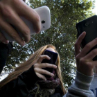 Adolescentes utilizando teléfonos móviles.-FERRAN NADEU