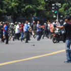 Un hombre armado apunta hacia un centro comercial mientras decenas de personas corren, en el centro de Yakarta.-AP / VERI SANOVRI