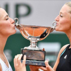 Kristina Mladenovic (derecha) y Timea Babos besan el trofeo de campeonas de dobles de Roland Garros.-AFP / MARTIN BUREAU