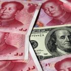 Billetes de yuan junto a un dólar-REUTERS / PETAR KUJUNDZIC