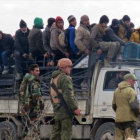 Salida de civiles y combatientes rebeldes Alepo bajo la estrecha vigilancia de soldados rusos y de las fuerzas progubernamentales esta semana.-AFP