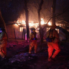 Bomberos en una casa en llamas en el sur de California.-AFP / MARK RALSTON