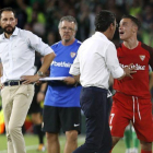 El jugador del Sevilla Roque Mesa (de rojo) protesta tras ser expulsado ante el Betis.-JOSE MANUEL VIDAL (EFE)
