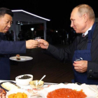 El presidente ruso, Vladimir Putin, brinda con su homólogo chino, Xi Jinping, en una feria alementaria en Vladivostok.-AFP / SERGEI BOBYLYOV