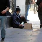 Un indigente pide ayuda a los traseúntes en una calle de Barcelona, ayer.-/ RICARD CUGAT