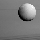 Panorámica de Dione con los anillos de Saturno al fondo.-Foto:  NASA / ESA