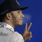Lewis Hamilton hace el signo de la victoria tras conseguir la 'pole' del GP de Baréin.-Foto:  AP / LUCA BRUNO