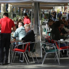 Un camarero atiende a clientes en una terraza. Es el colectivo con más contratos temporales.-DANNY CAMINAL