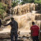 Policías y voluntarios frente a la cascada en la que un árbol mató a 18 personas.-CRISTINA ALDEHUELA