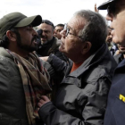 Inmigrantes afganos intentan bloquear la entrada del ministro al centro de refugiados.-THANASSIS STAVRAKIS