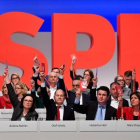 Miembros de la dirección del SPD votan, junto a los demás delegados, a favor de negociar con Merkel.-/ AFP / JOHN MACDOUGALL