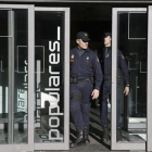 Dos policías salen de la sede central del PP, en la calle Génova de Madrid.-