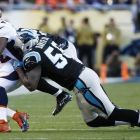 El running back de los Broncos J. Anderson, interceptado por Thomas Davis de los Carolina Panthers.-