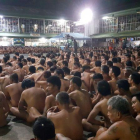 Cientos de presos obligados a desnudarse y sentados en fila en el patio de la cárcel de Cebú.-AFP
