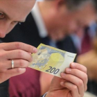 Un periodista inspecciona un nuevo billete de 200 euros, presentados este lunes.-ARMANDO BABANI