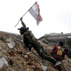 Un soldado del Ejército sirio coloca una bandera nacional durante una batalla con combatientes rebeldes en Alepo.-HASSAN AMMAR (AP)