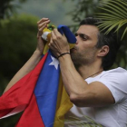 Leopoldo López besa la bandera venezolana tras ser liberado.-AP / ARIANA CUBILLOS