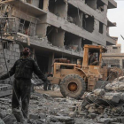 Civiles y voluntarios de la Defensa Civil Siria buscan sobrevivientes tras varios ataques aéreos en la ciudad de Hamoria, en Guta.-EFE / MOHAMMED BADRA