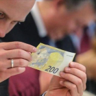 Un periodista inspecciona un nuevo billete de 200 euros.-ARMANDO BABANI