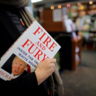 Una mujer sostiene un ejemplar de Fire and Fury, en una librería de Washington (EEUU).-CARLOS BARRIA (REUTERS)