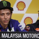 Valentino Rossi explica sus sensaciones antes del Gran Premio de Malasia, bajo la atenta mirada de Marc Márquez.-AP / JOSHUA PAUL