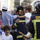 Un bombero con un niño en brazos durante la marcha-ALBERT BERTRÁN