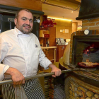Alberto López  saca un cochinillo del horno de leña del restaurante El Fogón de Salvador.-ÁLVARO MARTÍNEZ