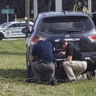 Agentes de policía se protegen tras su vehículo durante el tiroteo en el banco de Florida, este miércoles.-AP