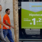 Un anuncio de hipotecas en el escaparate de una oficina bancaria, el pasado agosto en Madrid.-JOSÉ LUIS ROCA