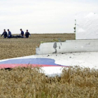 Varias personas transportan un cadáver en una camilla en medio de los destrozos de un Boeing 777, vuelo MH17 de Malaysia Airlines, derribado cerca de Donetsk (Ucrania).-EFE / ANASTASIA VLASOVA