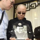 Liu Xia, esposa del premio Nobel de la Paz fallecido Liu Xiaobo, muestra una foto de su marido en día del funeral.-AP