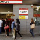 Una fila de parados en una oficina de empleo.-