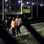 Tres inmigrantes se encaminan por las vías del tren con la intención de acceder al Eurotúnel, cerca de Calais.-REUTERS