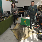 Heredia y Velarde en una de las dependencias llenas de objetos recuperados, con las armas de fuego a la derecha de la imagen. / VALENTÍN GUISANDE-