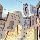 Una mujer cuelga carteles de chilenos desaparecidos en la cerca de Colonia Dignidad, que sirvió de centro de tortura de Pinochet.-REUTERS