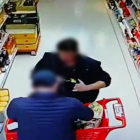 El detenido escondiendo bajo su ropa una de las botellas sustraídas en el supermercado de El Burgo de Osma.-HDS