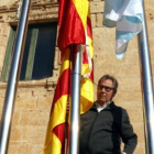 El alcalde de Torredembarra, Eduard Rovira, junto al mástil en que ha colocado la bandera española y, debajo, la 'senyera'.-ACN