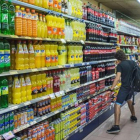 Un joven, ante la estantería de refrescos de cola, en un supermercado-/ FERRAN SENDRA