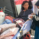 Una mujer atiende a su marido, herido en el terremoto de Lombok, en el hospital de Mataram.  /-KIKI SIREGAR (AFP)