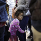 Una niña mexicana con su madre espera con otros inmigrantes en la frontera la respuesta a la solicitud de asilo político en EEUU.-GREGORY BULL