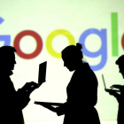 Siluetas ante el logo de Google.-DADO RUVIC (REUTERS)