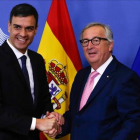 Sánchez y Juncker se saliudan antes de la reunión que han mantenido previa a la cumbre de la UE.-AFP