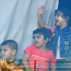 Niños refugiados sirios miran a través de la ventana de un autobús antes de abandonar Beirut este domingo de regreso a sus hogares en Siria.-EFE / WAEL HAMZEH