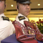 Guardias de seguridad custodian unos zapatos con rubís y platino valorados en 1,47 millones de euros, en Harrods.-EPA