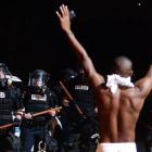 Un joven levanta los brazos ante la policía en Charlotte.-JEFF SINER / AP