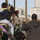 Unos niños montan en un tiovivo en presencia de adultos, en Madrid.-DAVID CASTRO