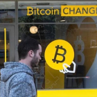 Un ciudadano israelí pasa delante de una oficina de cambio de bitcoines, en Tel-Aviv.-AFP/JACK GUEZ
